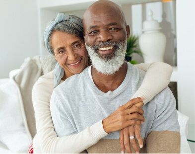 Older couple embracing and smiling in their home